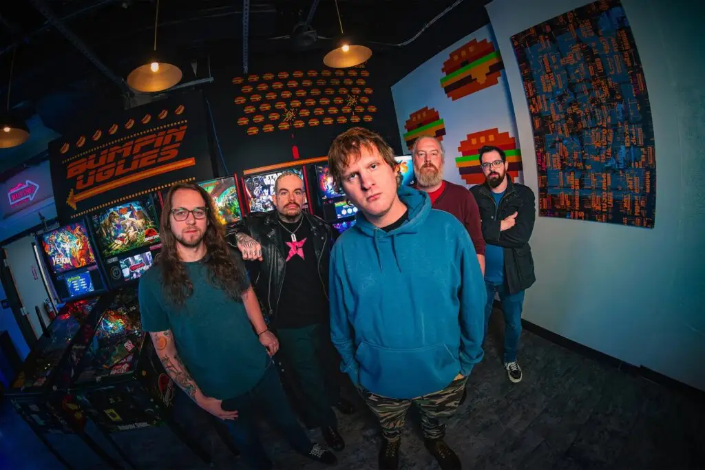 Bumpin Uglies five-piece band poses for their 2026 official press photo in an arcade bar setting