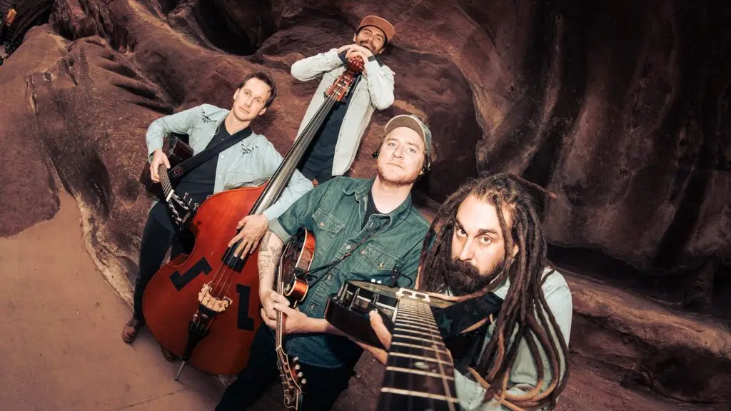 Kitchen Dwellers four-piece band with upright bass, mandolin, and acoustic guitars in red rock canyon