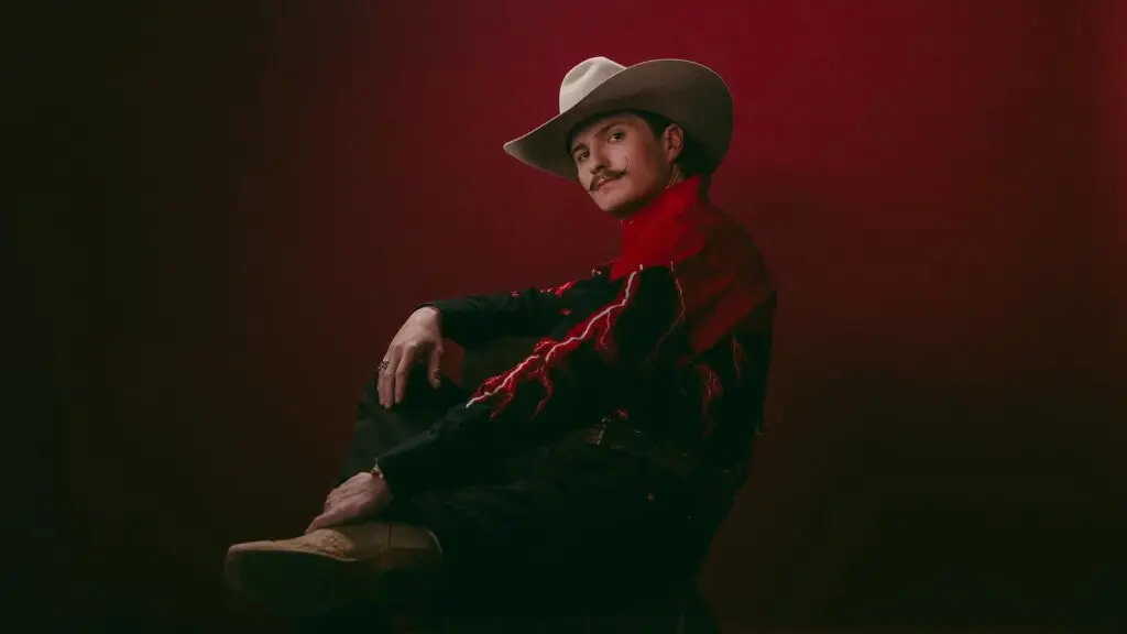 Braxton Keith in Western attire seated in a dramatic studio portrait