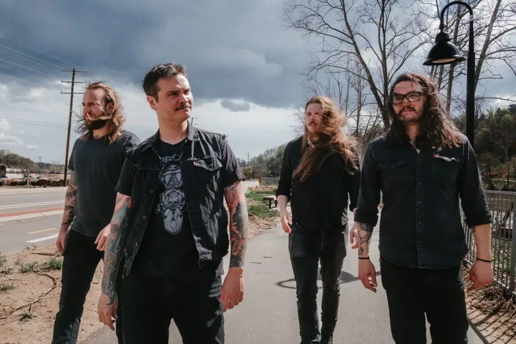Howling Giant, Nashville heavy psych band, four members walking outdoors under dramatic stormy sky