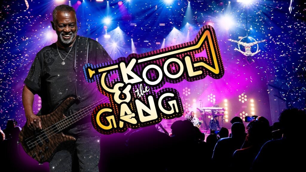 Kool & the Gang performing live with Robert Bell on bass, confetti raining down on a lit concert stage
