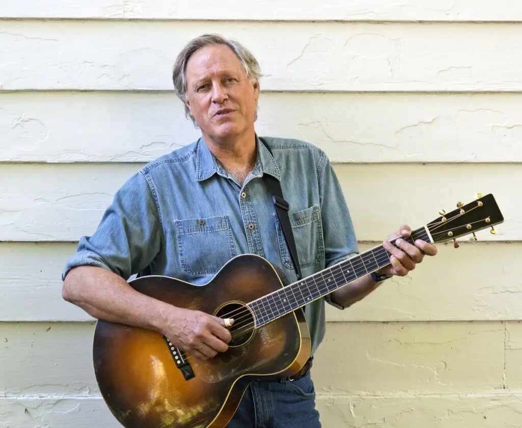 Tom Chapin holding acoustic guitar, official press photo