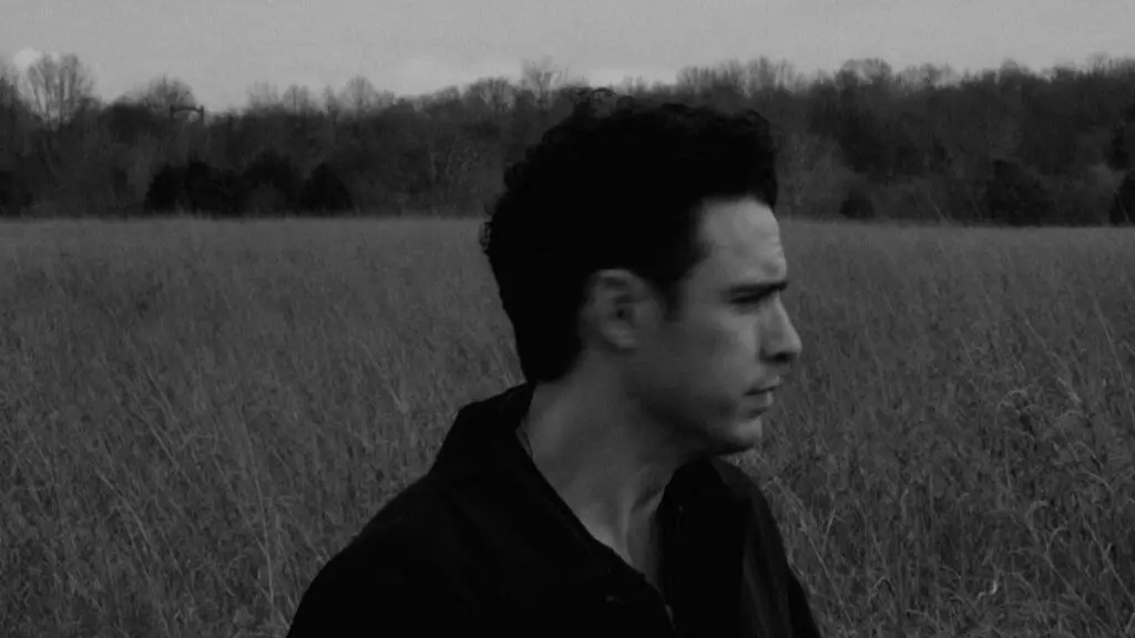 Marc Scibilia, folk-rock singer-songwriter from Buffalo, in a black-and-white press photo in a field