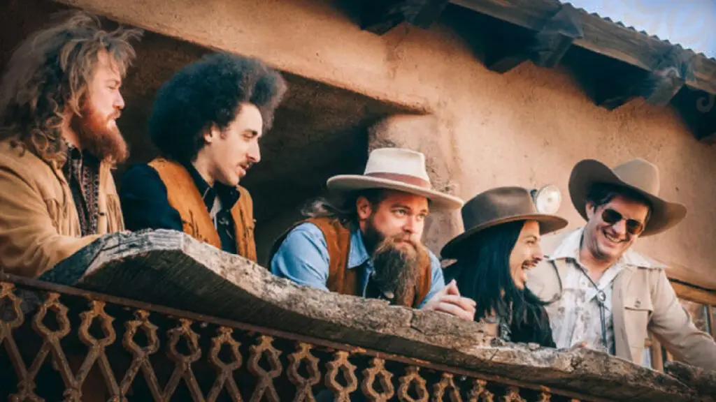 Robert Jon & The Wreck band members posed on a rustic balcony in a Southwestern setting