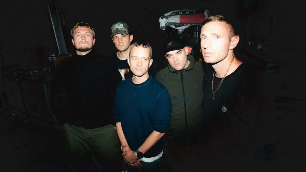 High Vis band press photo — five members posed together in a dark backstage setting