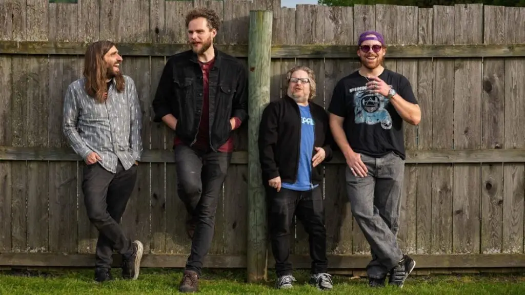 Night Zero band posed in front of a wooden fence — jam supergroup featuring members of Dopapod, Twiddle, and Kung Fu