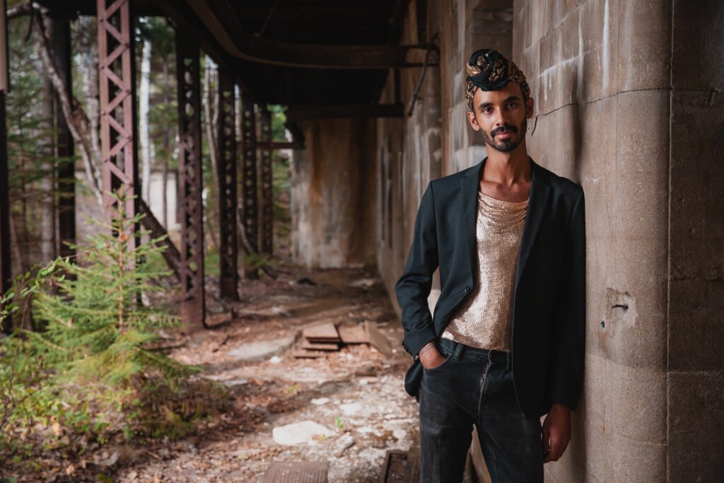 Jake Blount, folk musician and banjo player, in black blazer and gold sequined top, official press photo by Tadin Brown