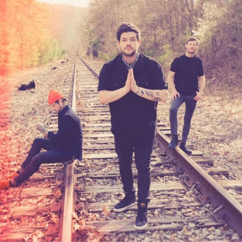 The Spill Canvas — three band members posed on railroad tracks with autumn foliage