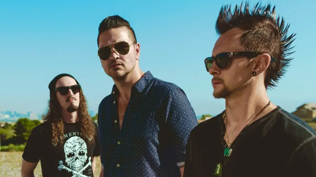 Adelitas Way band members pose outdoors in desert setting, promotional press photo