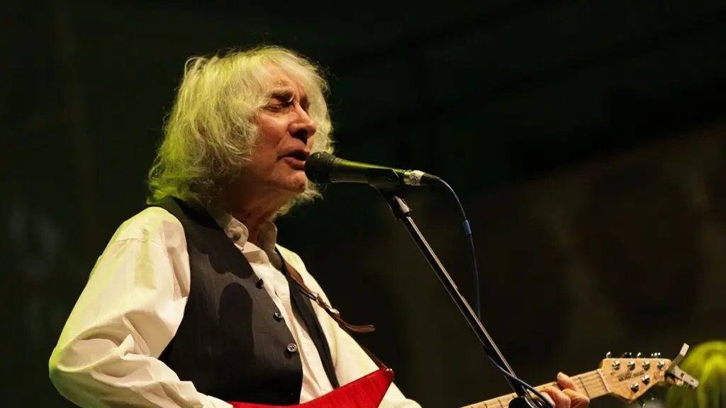 Albert Lee performing live on stage with his signature red Music Man guitar