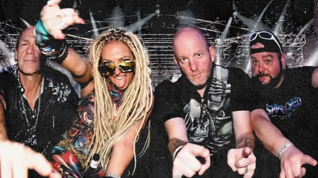 Pulsifier band promotional photo, four members pointing at camera against stage lighting backdrop