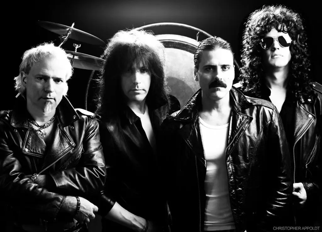 Almost Queen, Queen tribute band, four members posed in dramatic black-and-white official press photo