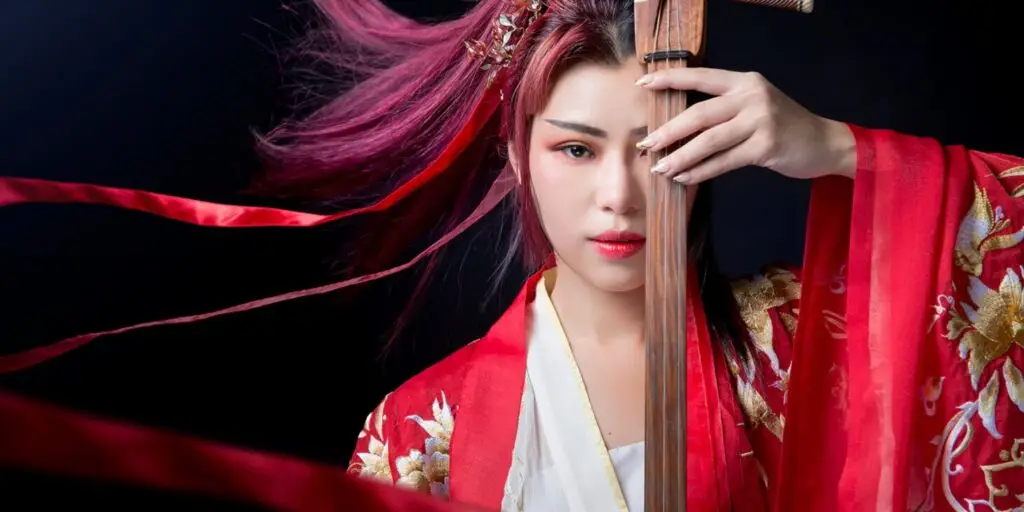 NiNi playing traditional Chinese Ruan instrument in embroidered red hanfu robe