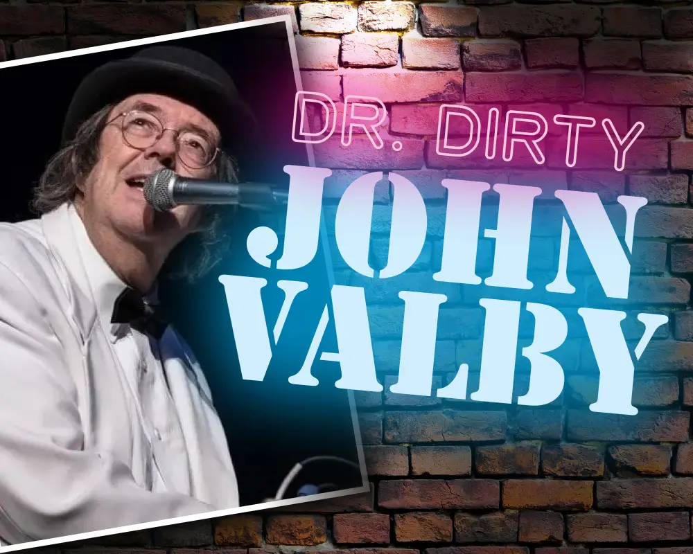 Dr. Dirty – John Valby performing at microphone in signature white shirt and black derby hat