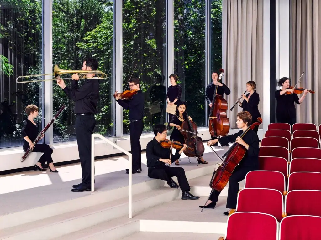 Buffalo Chamber Players chamber ensemble performing — strings, trombone, and woodwinds in formal black concert attire