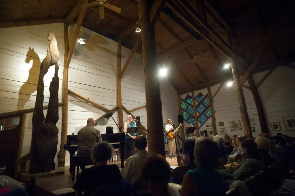 Live performance inside Maverick Concert Hall, Woodstock NY — pianist at grand piano, vocalist, and guitarist on stage