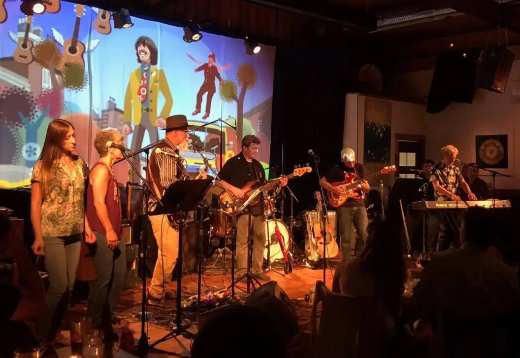 The Dark Horses tribute band performing live on stage with Yellow Submarine animation backdrop