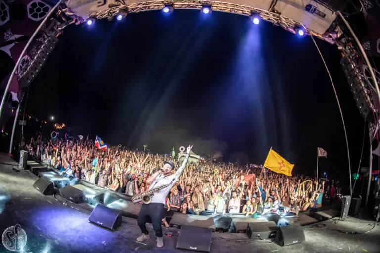 SoDown performing live at Sonic Bloom festival, playing saxophone on stage with energetic crowd