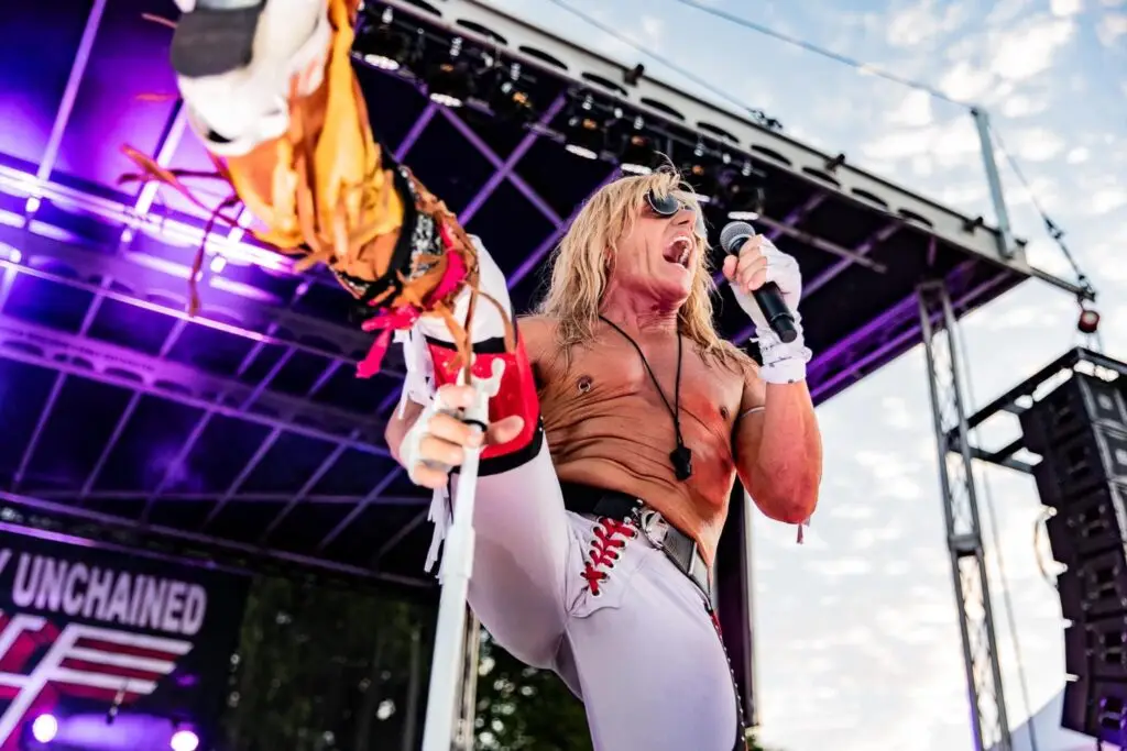 Completely Unchained frontman Little Geno performing live on outdoor stage, Van Halen tribute