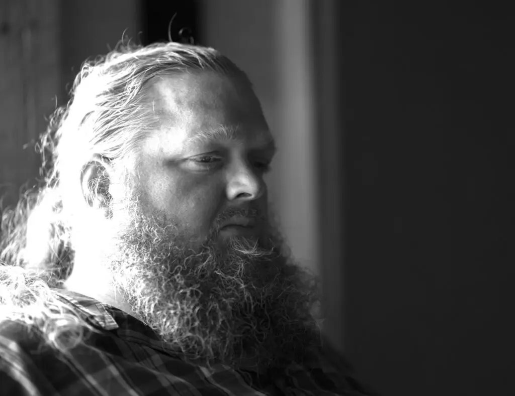 Matt Andersen in a dramatic black-and-white portrait with long flowing hair and full beard
