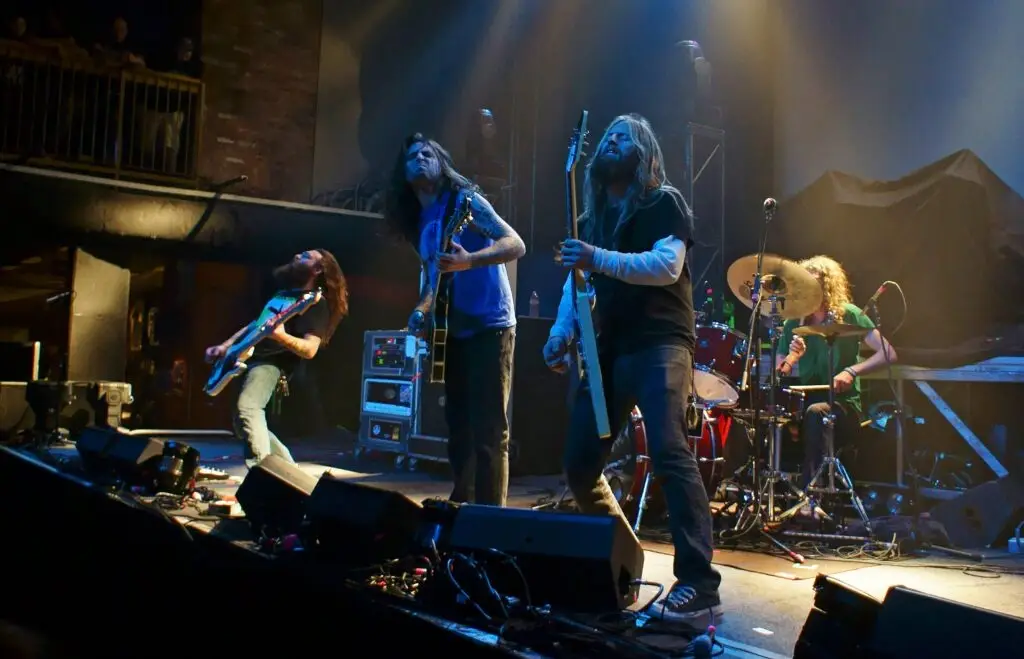 Darkest Hour performing live on stage, guitarists and drummer in a club venue