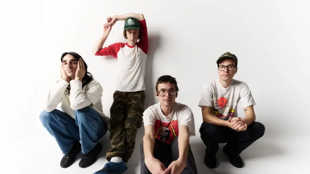 DIIV band promotional photo — four members posed against white backdrop