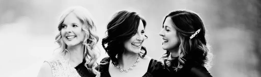 The Ennis Sisters laughing together in a black-and-white press photo
