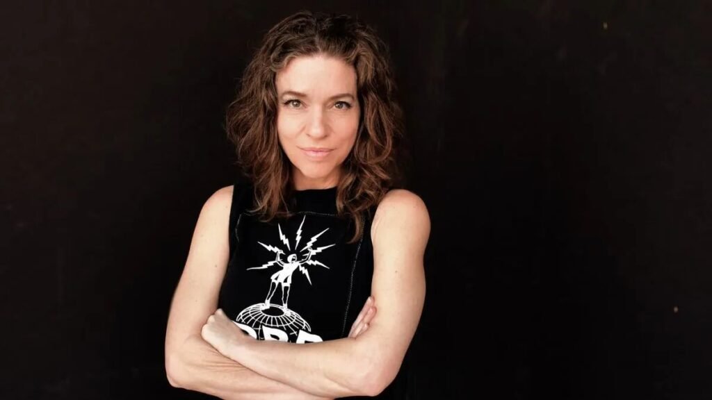 Ani DiFranco poses with arms crossed in her 2026 Spirit of Love Tour press photo