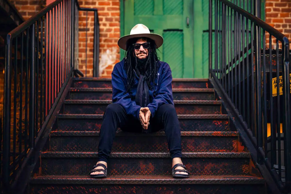 Don Was, leader of the Pan-Detroit Ensemble, in a 2026 press photo seated on urban stairs