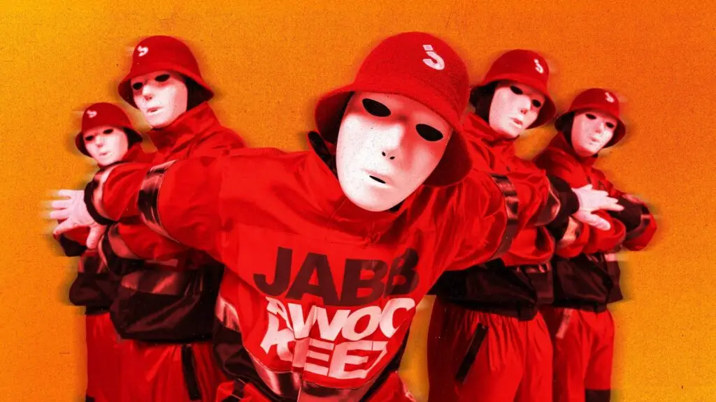 Jabbawockeez dance crew in white masks and red outfits performing in formation