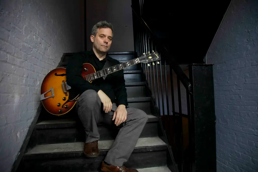 Will Bernard with hollow-body Gibson guitar, official press photo