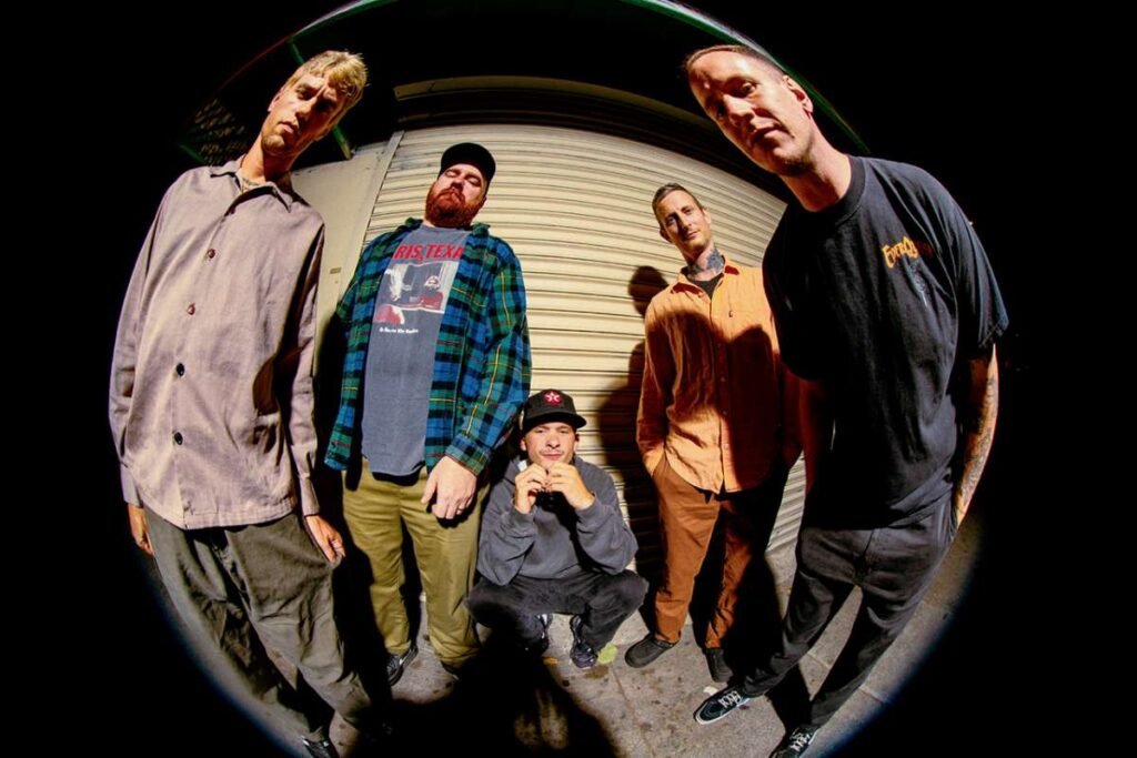 Drug Church five-piece band pose with fisheye lens outside at night