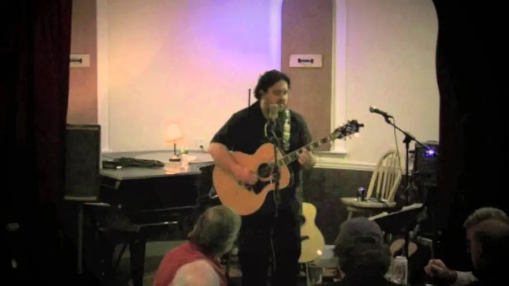 Jack Waldheim performing live solo with acoustic guitar at an intimate indoor venue