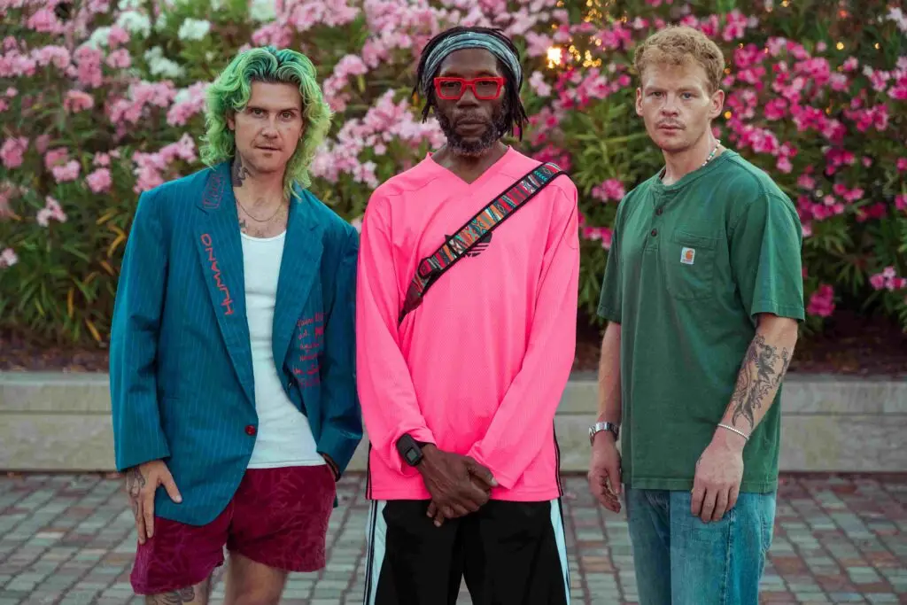 Too Many Zooz trio standing outdoors before a concert, professional press photo