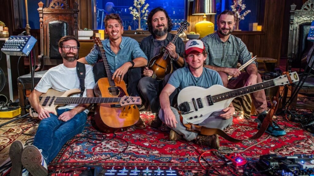 Fireside Collective band photo — five musicians with mandolin, guitar, and bass in a studio session