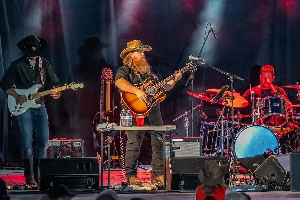 Outlaw State of Mind performing live on stage — lead vocalist with long beard and cowboy hat on acoustic guitar, with full band