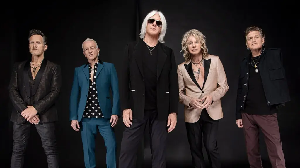 Def Leppard — all five members in official press portrait, black studio backdrop