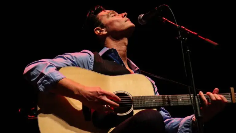 A Man Named Cash performer plays acoustic guitar at microphone on stage
