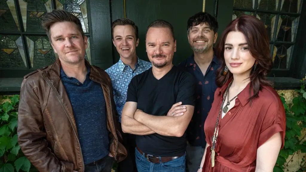 Gaelic Storm, five-piece Celtic band, pose for press photo outside a building with stained glass