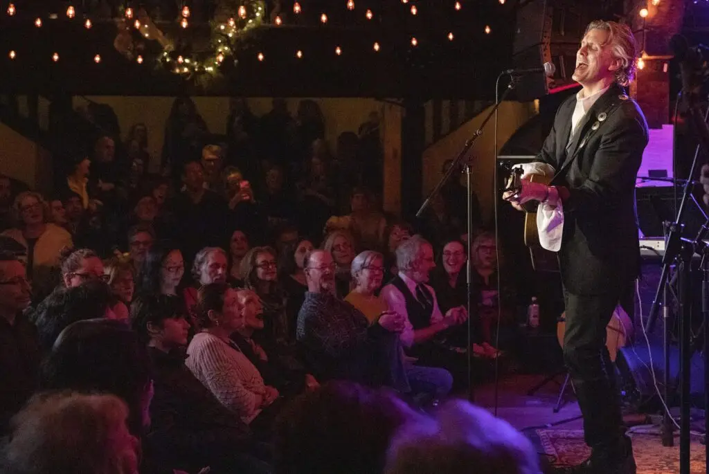 Robert Burke Warren singing with acoustic guitar at the Bowie Birthday Bash, Colony Woodstock