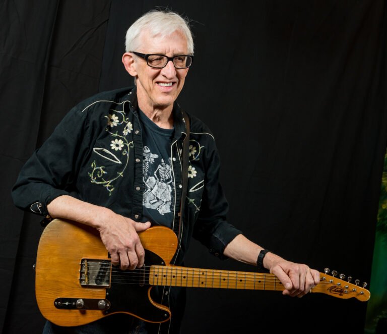 Bill Kirchen holding his vintage Fender Telecaster guitar, official press photo