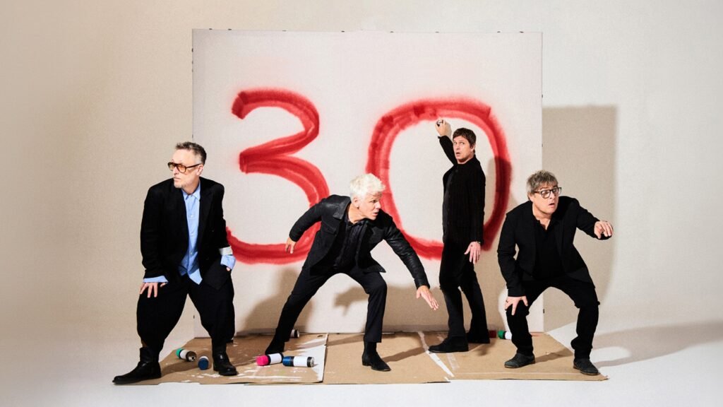 Matchbox Twenty pose before a giant red-painted '30' backdrop for their 30th anniversary tour