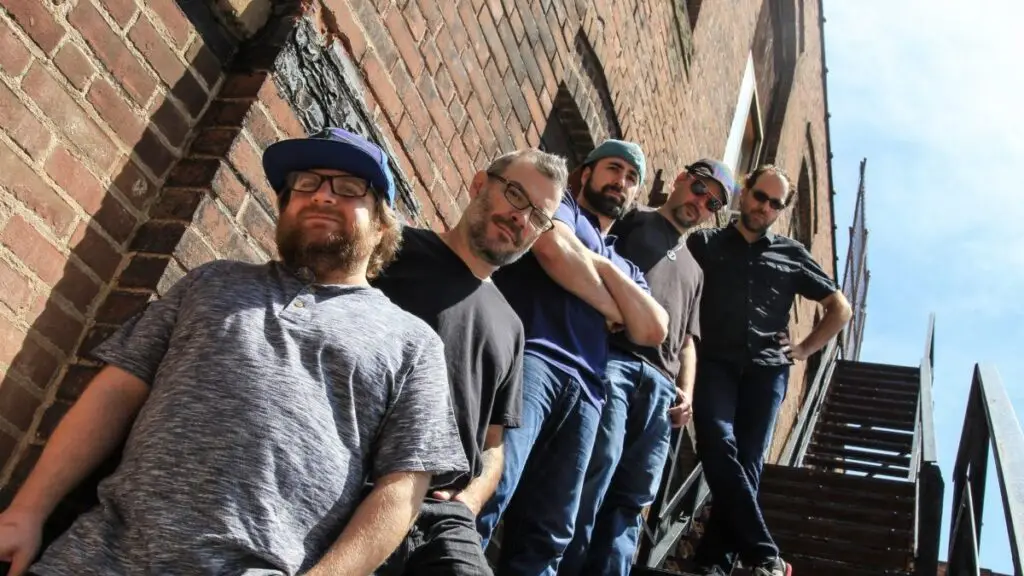 Kung Fu band press photo — five members posed on fire escape stairs against brick wall