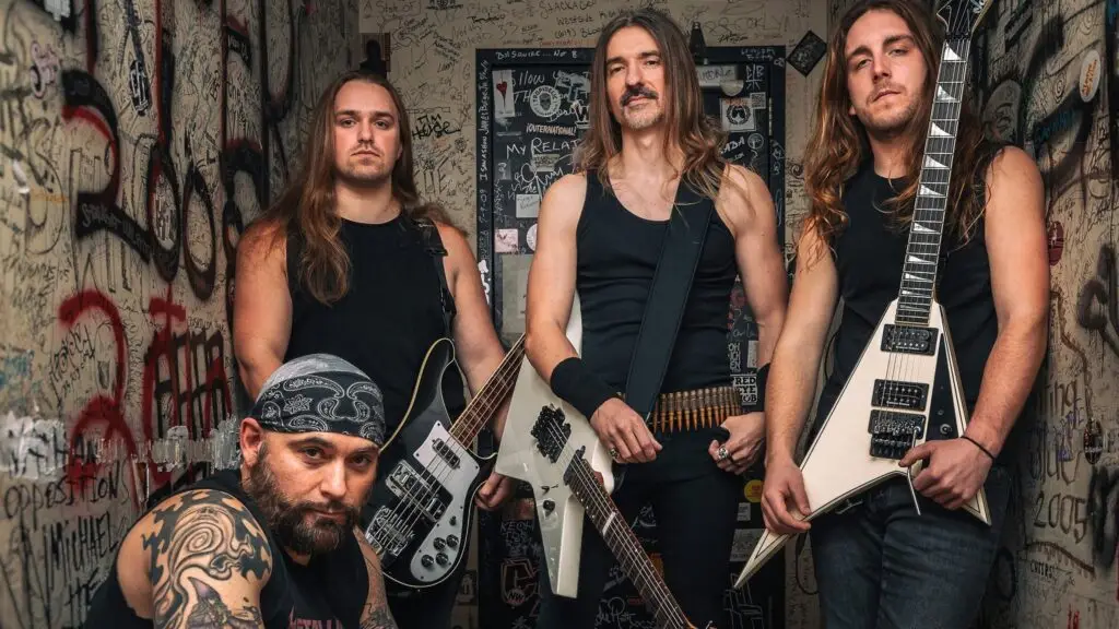 The Four Horsemen Metallica tribute band members pose with guitars in a graffiti-covered backstage corridor