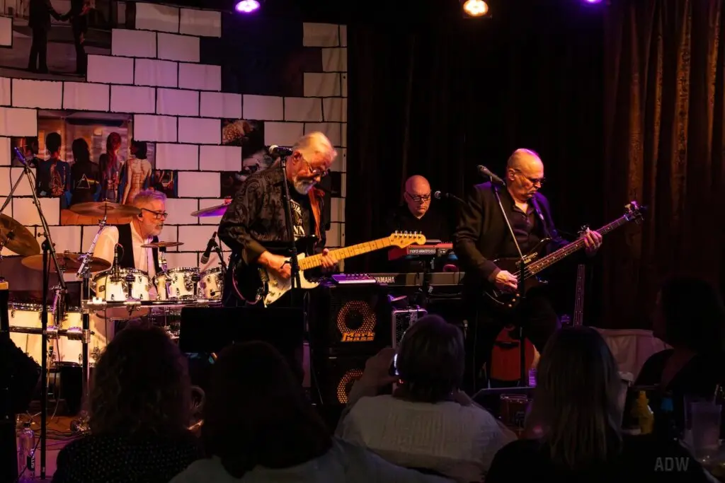Heroes for Ghosts Pink Floyd tribute band performing live on stage with The Wall brick backdrop