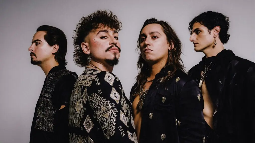Greta Van Fleet, all four members in a promotional press photo wearing dark ornate attire