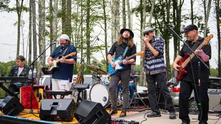 Cryin' Out Loud performing live outdoors, full band on stage with guitars, keyboard, and drums