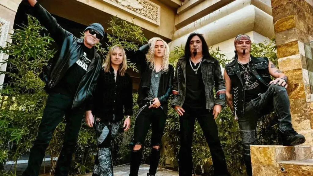 Great White band promo photo — five members in leather jackets, outdoor courtyard