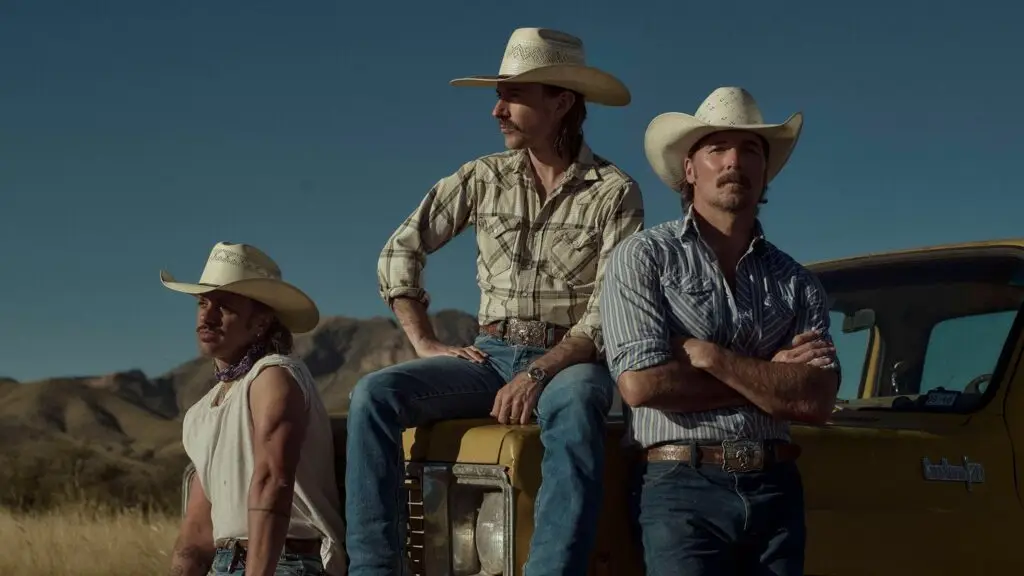 Midland, Texas country trio, in cowboy hats and western attire posed at a vintage yellow pickup truck