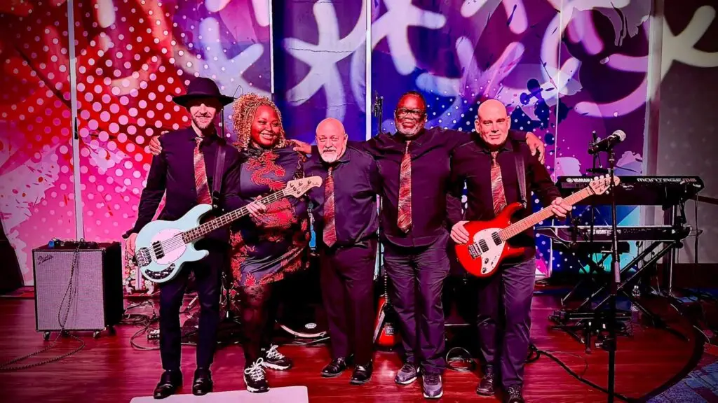 The Rhythm Pilots five-piece band poses on stage with instruments at a casino performance